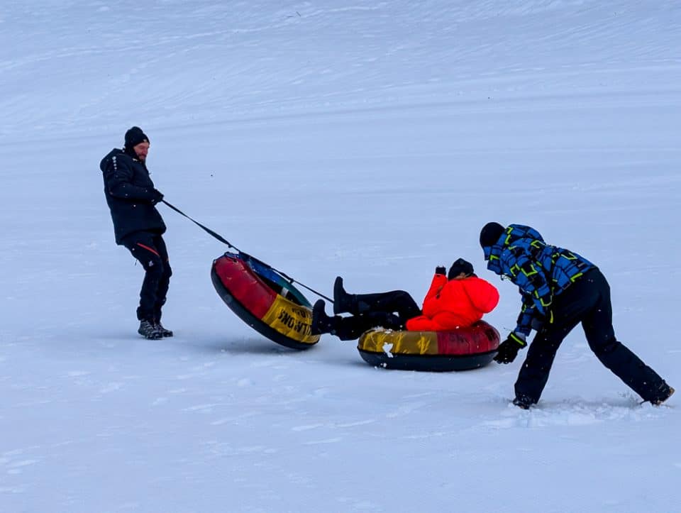 Kinder und Teenager beim Snowtubing in Kössen, Winterurlaub Kaiserwinkl