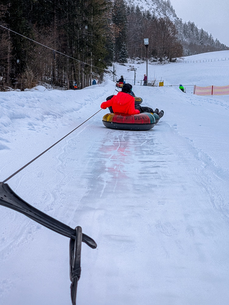 Kinder und Teenager beim Snowtubing in Kössen, Winterurlaub Kaiserwinkl