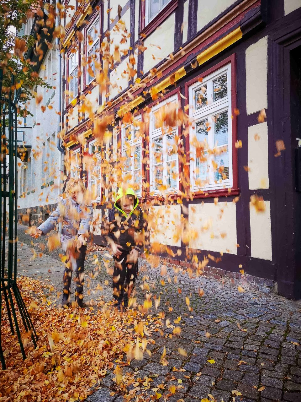 Blätterwerfen mit Kindern im Herbst