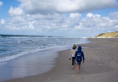 Kinder spazieren am Strand während des familienurlaubs in deutschland mit kindern