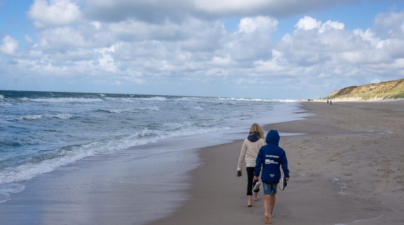 Kinder spazieren am Strand während des familienurlaubs in deutschland mit kindern