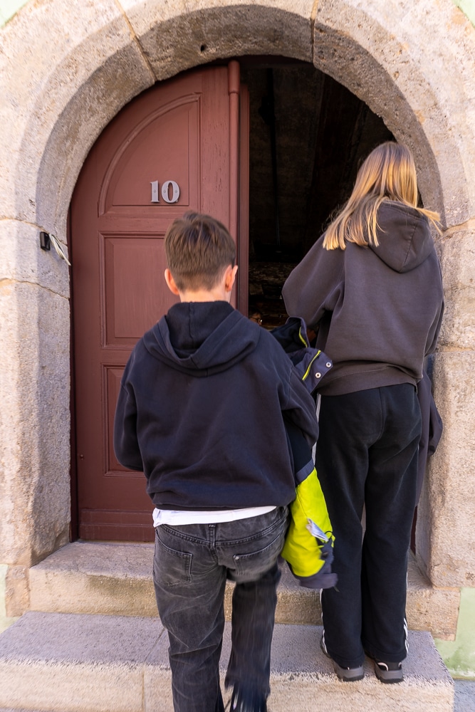 Kinder gehen durch eine historische Tür in der Judengasse in Rothenburg