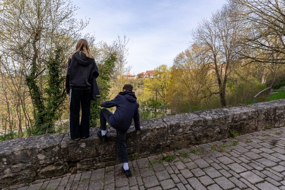 Kinder stehen auf der Stadtmauer und schauen ins Tal bei Rothenburg