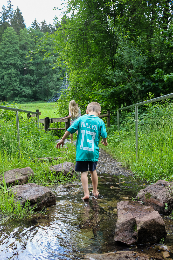 Kinder laufen durch den Barfußpark im Schwarzwald