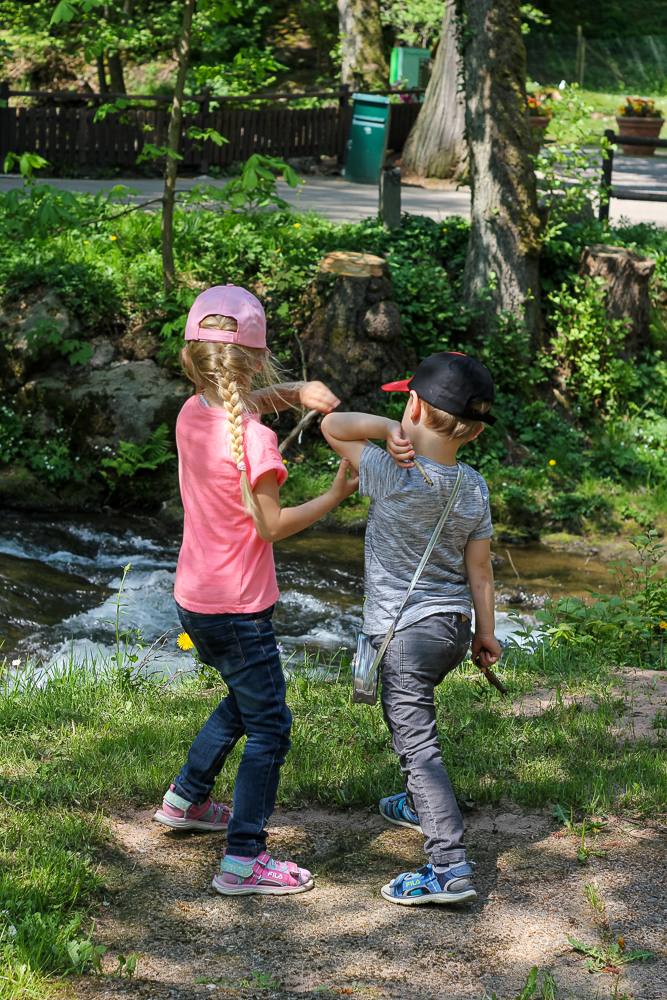 Kinder werfen Steine in den Fluss im Kurpark Bad Wildbad