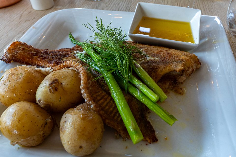 Gebratener Fisch mit Kartoffeln und grünem Spargel im Restaurant Trekosten in Nivå